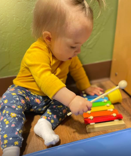 Child playing with a colorful toy xylophone
