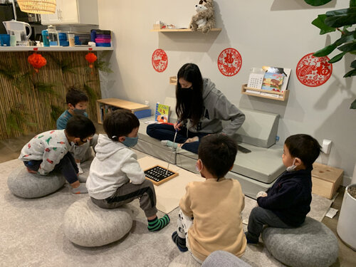 Person reading to children sitting on floor cushions